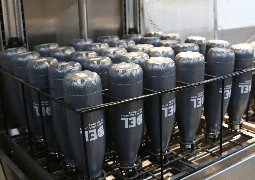 Nettoyage de gourdes approfondi et efficace dans une machine laveuse de contenants professionnelle.