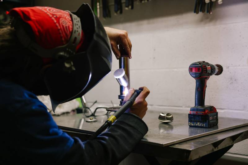 Stainless steel welder working on a pipe for bottle cleaner machine