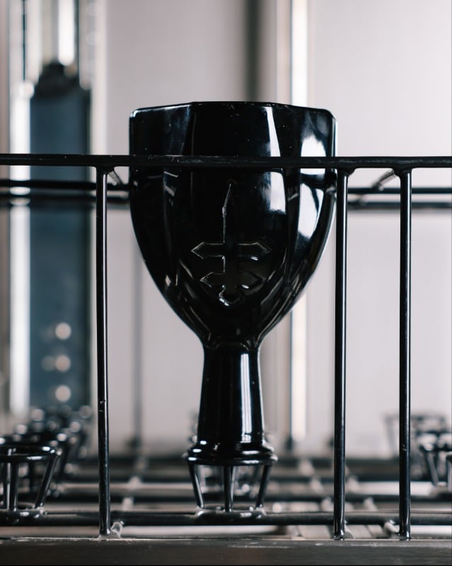 Black glass bottle in cleaner and sanitizer machine