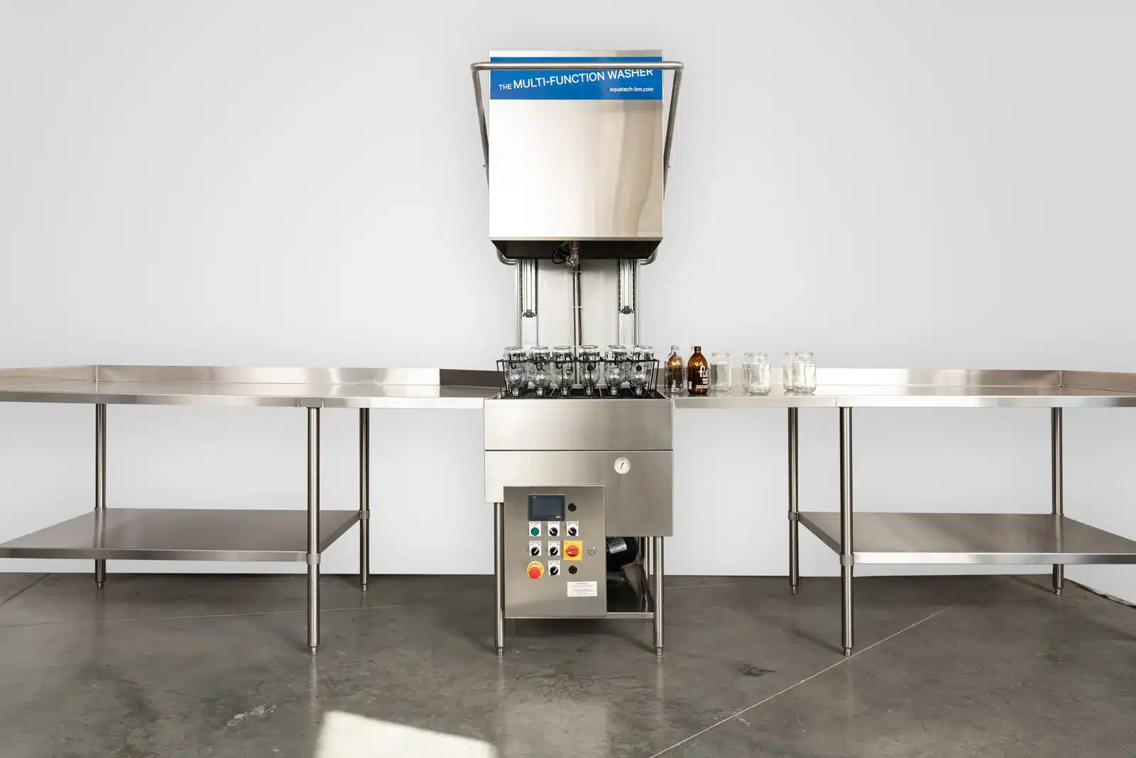Lave-bouteilles professionnel multifonction AquaTech BM en inox, entre deux tables de travail